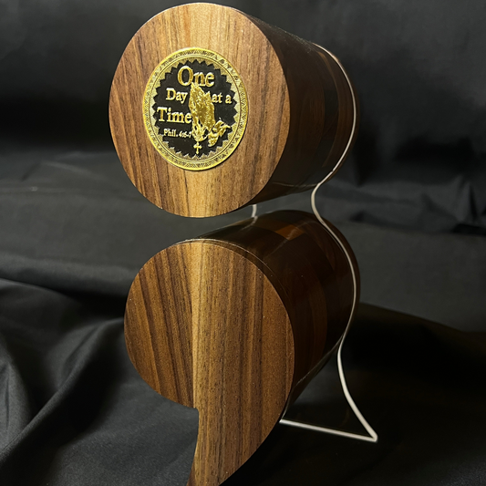 A black walnut semicolon keepsake box with a gold and black "One Day at a Time" coin embedded on the top.