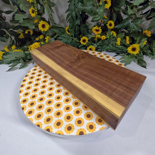 Wooden box on a sunflower-patterned plate with flowers in the background